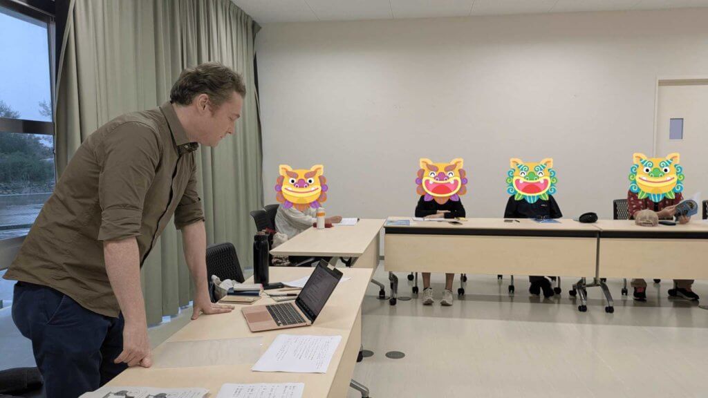 名護言葉講座のようす。講師のハイス先生が立ち上がって説明をしている。